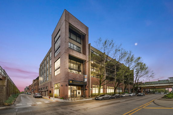 Front view of a multi-story brick building with large windows and a modern design.