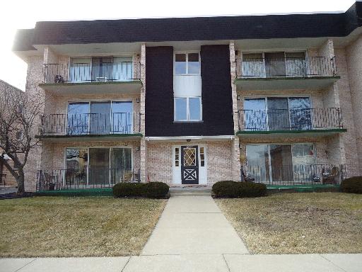 Front view of a three-story residential building with balconies.