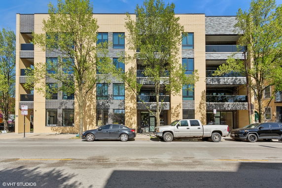 Front view of a modern multi-story apartment building with brick facade.