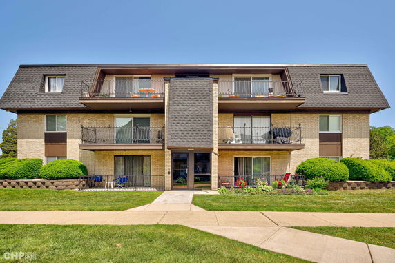 Front view of a three-story apartment building with balconies.