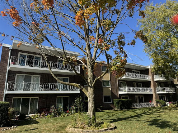 Front view of a multi-story apartment building with balconies.