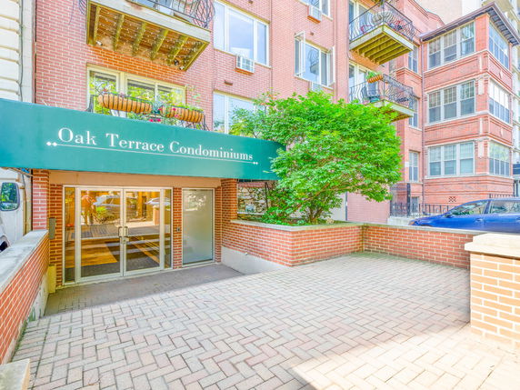 Front view of a condominium entrance with a green awning.