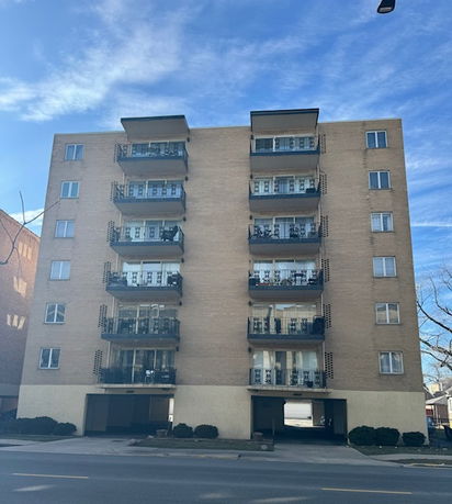 Front view of a multi-story apartment building with balconies.