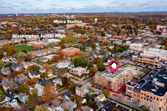 Aerial view highlighting a community with various buildings and a nearby school.