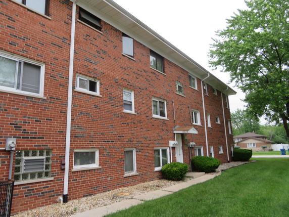 Front view of a multi-story brick apartment building.