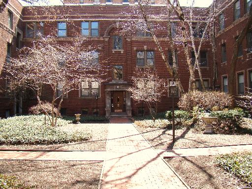 Front view of a multi-story brick building with arched doorways.