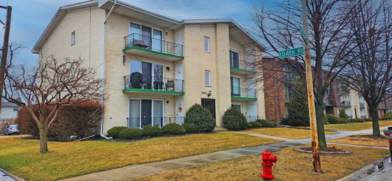 Front view of a multi-story apartment building with balconies.