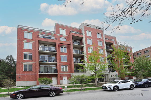 Front view of a multi-story brick apartment building with balconies.