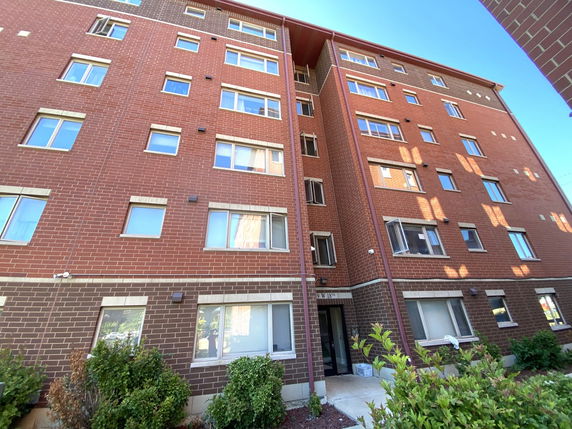 Front view of a multi-story brick apartment building.