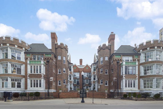 Front view of a brick building with castle-like towers.