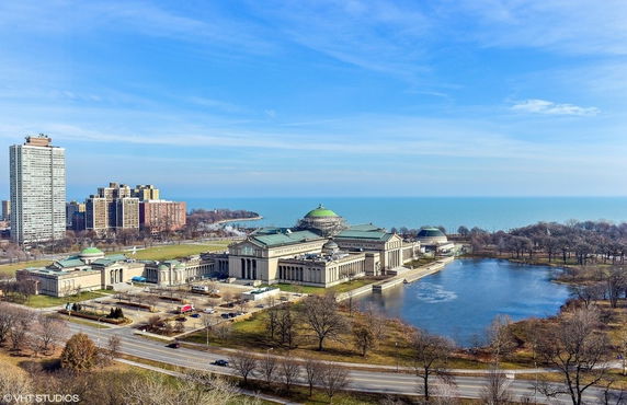 Aerial view of a large neoclassical building complex near a body of water.