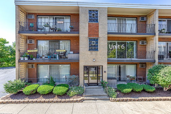 Front view of a multi-story apartment building with balconies.