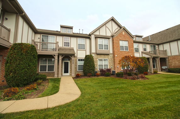 Front view of a two-story residential building with multiple entrances and balconies.