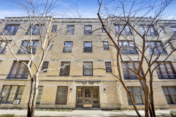 Front view of a multi-story brick building with multiple windows and a central entrance.
