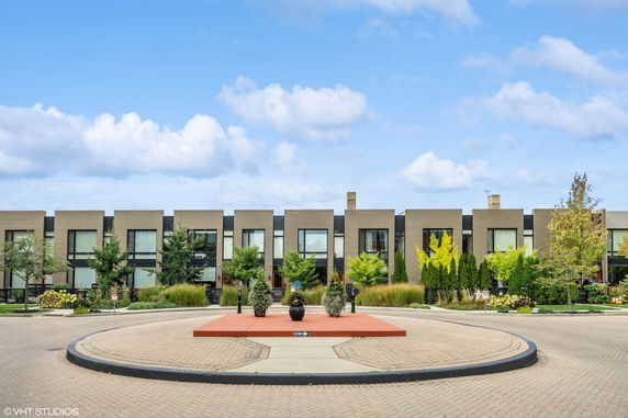 Front view of a modern multi-story building with large windows and landscaping.