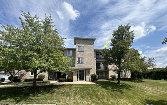 Front view of a three-story residential building with a brick facade.