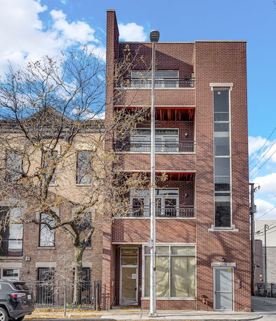 Front view of a multi-story brick building with balconies.