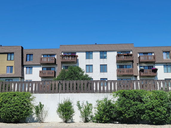 Front view of a multi-story apartment building with balconies.