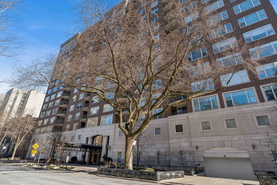 Front view of a multi-story apartment building with large windows and balconies.