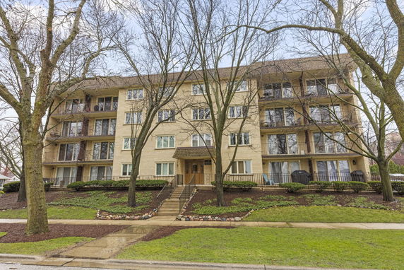 Front view of a multi-story apartment building with balconies.