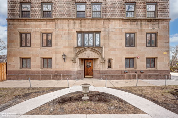 Front view of a multi-story building with brick and stone facade.
