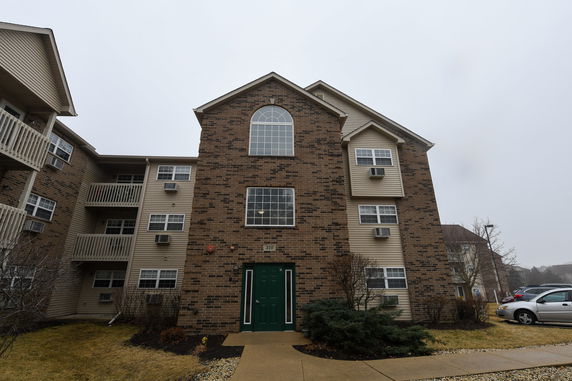Front view of a multi-story apartment building with brick facade and multiple windows.