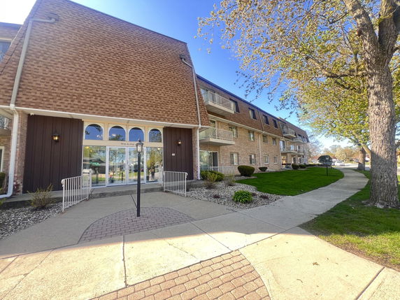 Front view of a multi-story apartment building with balconies.