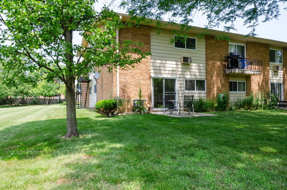 Side view of a two-story building with a patio and balcony.