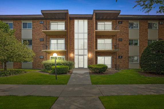 Front view of a three-story apartment building with balconies.