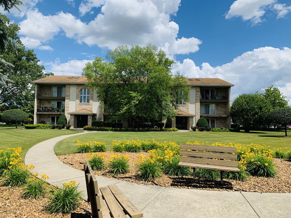 Front view of a three-story apartment building with balconies.