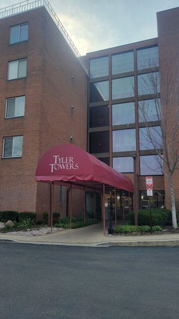 Front view of a multi-story brick building with an entrance canopy.
