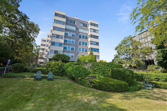 Front view of a multi-story residential building with landscaped garden.