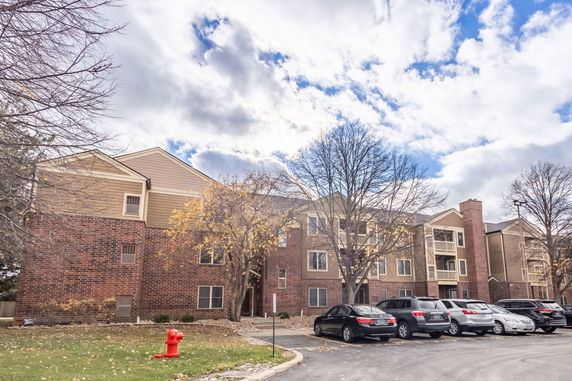 Front view of a multi-story residential building with brick and siding exterior.