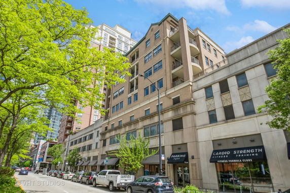 Front view of a multi-story urban building with retail spaces on the ground level.