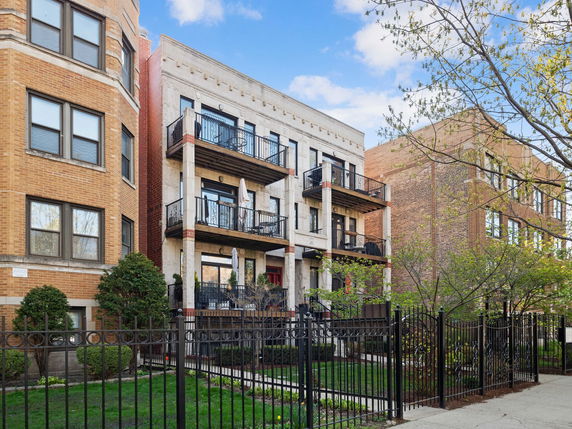 Front view of a multi-story residential building with balconies.