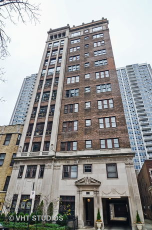 Front view of a multi-story brick and stone building.