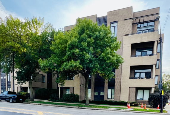 Front view of a multi-story brick building with balconies.