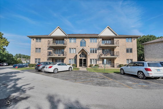 Front view of a three-story apartment building with balconies.
