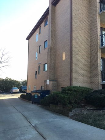 Side view of a multi-story brick building with balconies.
