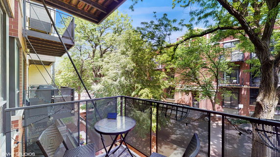 View from a balcony overlooking surrounding buildings and trees.