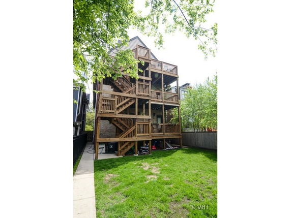 Rear view of a multi-story building with wooden staircases and decks.