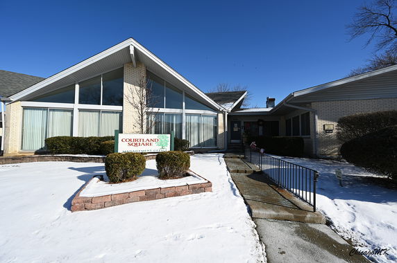 Front view of a management office building with a modern triangular roof design and large windows.