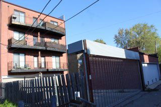 View of a multi-story residential building with balconies and an attached garage.