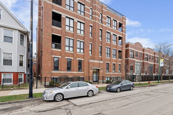 Front view of a multi-story brick building with multiple windows and balconies.