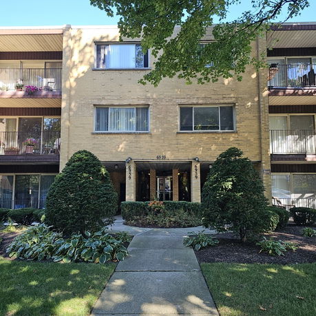 Front view of a multi-story apartment building with balconies.