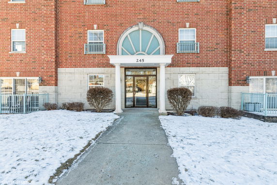 Front view of a brick building with a central entrance and multiple windows.