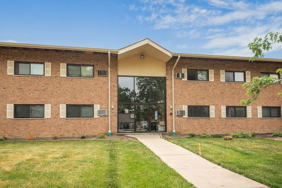 Front view of a two-story brick building with large central entrance.
