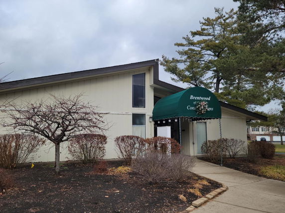 Front view of a single-story building with a green awning at the entrance.