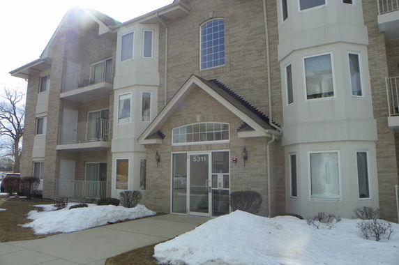 Front view of a multi-story building with balconies and large windows.