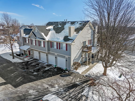 Front view of a multi-story suburban house with a garage during winter.
